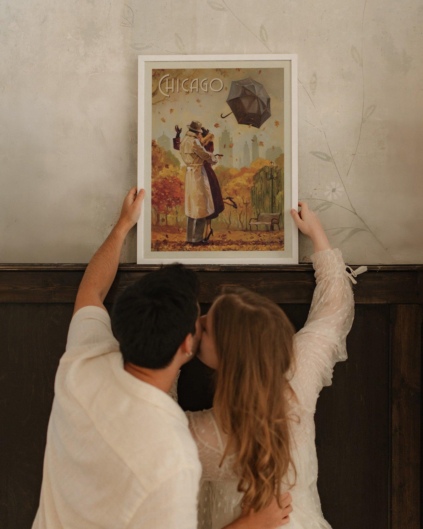 Couple kissing while hanging the white framed Chicago poster of lovers under a flying umbrella